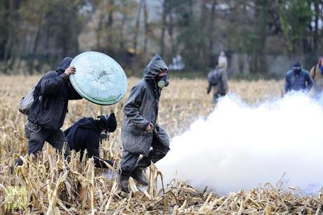 Protesters run on November 24, 2012 from tear gas shot by French riot police, seeking to evict squatters from protected swampland where Prime Minister Jean-Marc Ayrault wants to build a new airport (AFP Photo / Jean-Sebastuen Evrard)