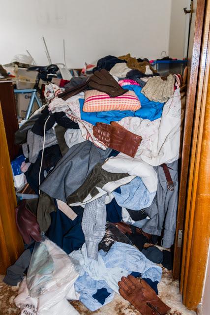 piled clothes in doorway of house