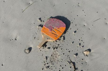 table tennis racquet washed up on sand