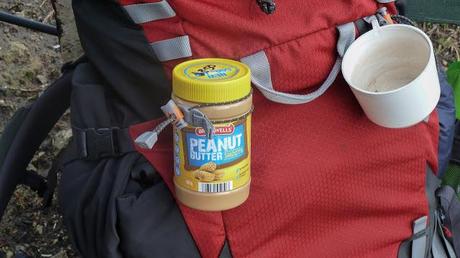 jar of peanut butter on outside of backpack 