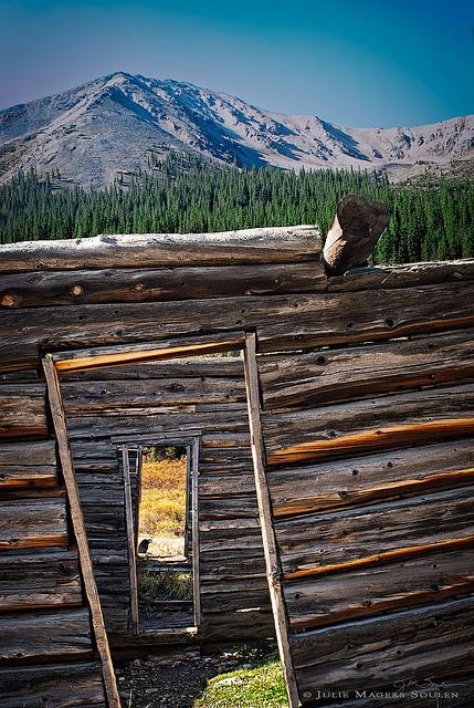 a rustic abandoned cabin with three crooked doorways