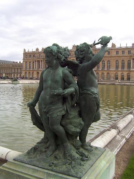 Palace of Versailles - Statue of children with a bird- along ornamental pool - France