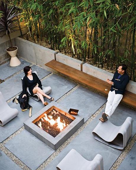 Backyard fireplace area with a long steel-and-ipe bench and Willy Guhl Loop chairs