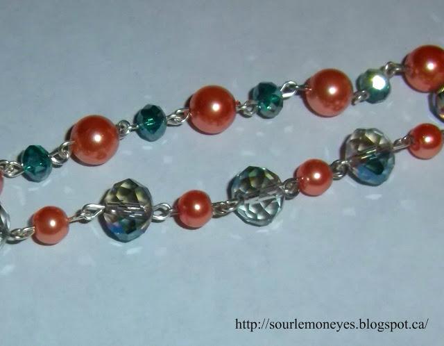 peach colored faux pearl necklace with blue and teal crystal beads