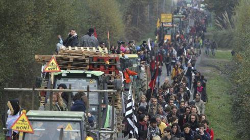This Nov. 17, 2012 file photo shows demonstrators walking along a road near Notre Dame des Landes, western France, as part of a protest against a project to build an international airport, in Notre Dame des Landes, near Nantes. An unlikely alliance of anarchists and beret-wearing farmers is creating a headache for President Francois Hollande’s beleaguered government by mounting an escalating Occupy Wall Street-style battle that has delayed construction on the ambitious airport near the city of Nantes for months. (AP Photo/David Vincent, File) (The Associated Press) 