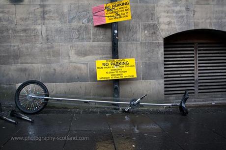 Photo - a unicycle left in front of a 'no parking' sign at Edinburgh's Fringe Festival