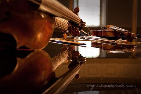 Photo - cello, viol and violin on a grand piano, at the Edinburgh Fringe Festival, Scotland