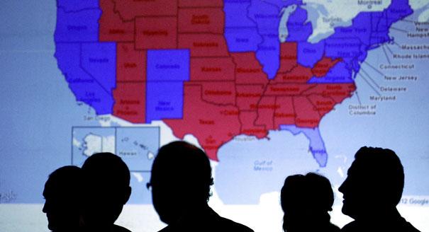 Silhouettes of people's heads are seen in front of an electoral map. | AP Photo 