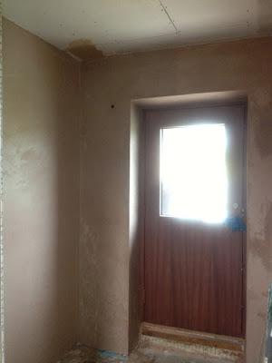 Plasterboard by front entrance plastered over and looking neat