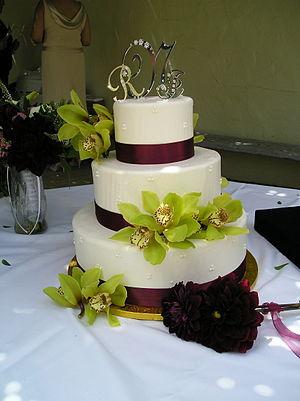 Wedding cake with green floral decoration.