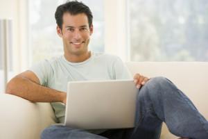 Student learning GIS on his laptop & smiling