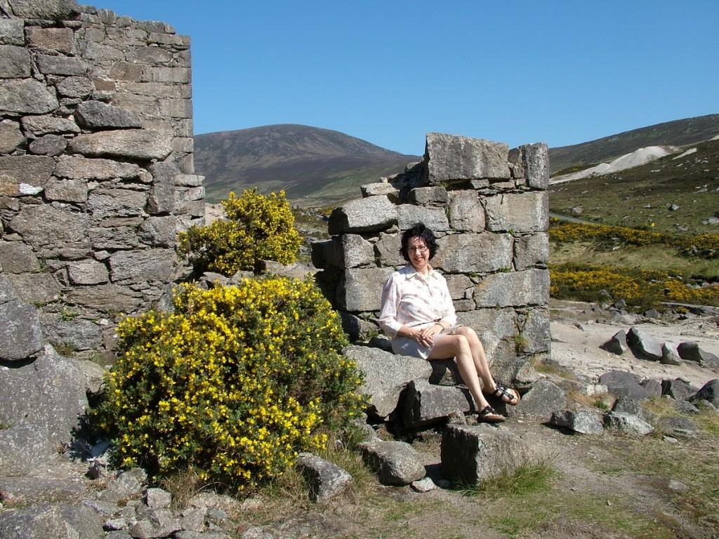 Hiking In Wicklow Mountains National Park – Ireland jean sits beside miners village ruins - glendalough - wicklow - ireland