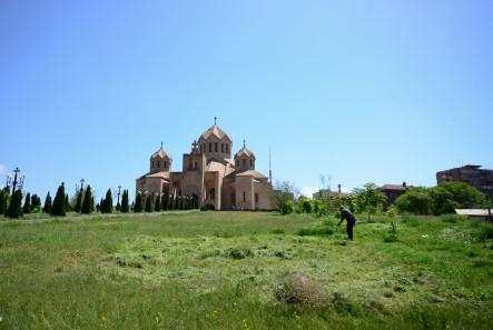 man cutting grass in front of Saint Gregory the Illuminator Cathedral Yerevan