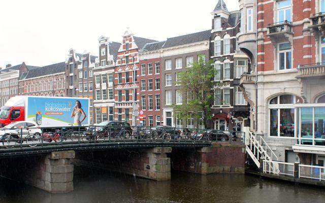 Amsterdam canal with bridge and monumental buildings.