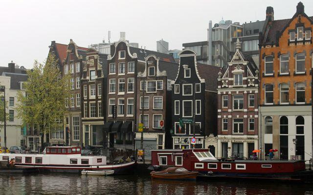 Amsterdam canal with houseboats and historic buildings