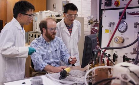 Michael Hickner, seated, along with research associates Yongjun Leng, left, and Nanwen Li review the data received from a specific polymer membrane that has been inserted into the fuel cell test stand. (Credit: Patrick Mansell / Pennsylvania State University)