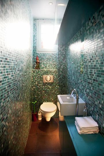 This small bathroom features remodeled floor and wall tiles that are great on a budget - and is that a gnome?
