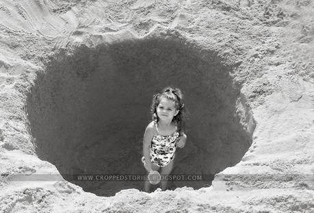 toddler in sand hole at beach