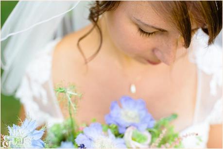 Bride looks down at wildflowert bouquet at UK wedding