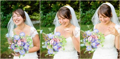 English bride sitting in garden smiling as she holds a multicoloured wildflower bouquet