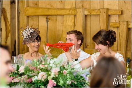 groom holds up red knickers during speeches as a joke in UK barn wedding at Old Green Barn