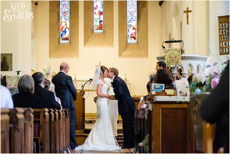 Groom kisses the bride at alter of UK church