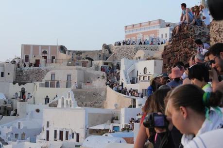 As the sun goes down over the Agean, thousands flock to the whitewashed walls of Oia to witness the sunset. 