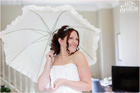 Bride smiles with with vicotial parasol at Woburn Abbey 