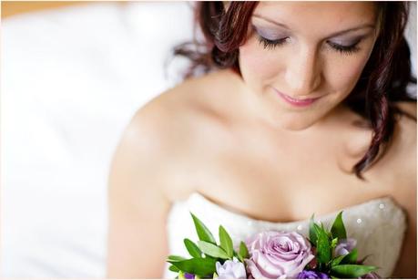 Bride looks at pruple flowers during wedding praparation 