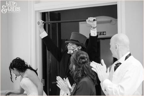 Groom holding cane over his head victoriously 