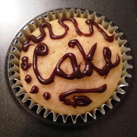 cake writing on cupcake in chocolate icing silver spoon decorating