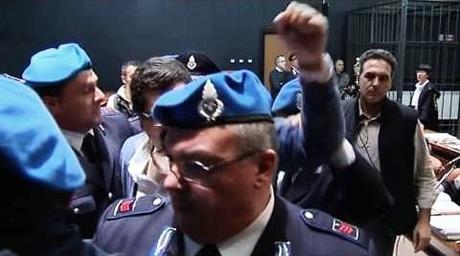 Reportback: First Day of Trial for Roberto Adinolfi Shooting Nicola with fist raised