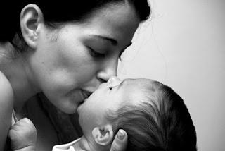 a mother kissing her child a mother kissing her child