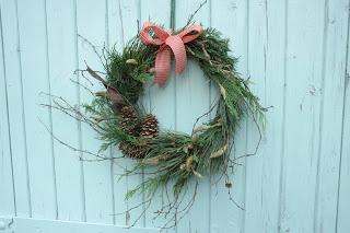 Freshly cut evergreen wreath with pine cones, magnolia and silver birch twigs.