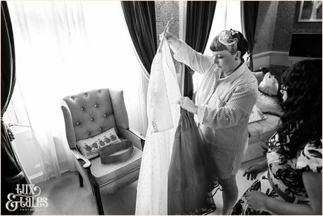 Julia & Chris Got Married! | Wedding Photography Bride looks at courutre company dress before she puts it on at vintage themed wedding in Yorkshire