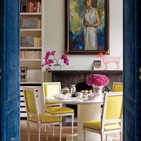 upholstered blue door and art in a white room