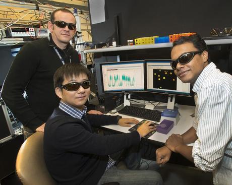 CFN's Mircea Cotlet (standing), post-doc Huidong Zang (center), and Prahlad Kumar Routh, a graduate student in the Materials Science Department at Stony Brook University, hope their research on quantum dots for solar cells will brighten our energy future. The scientists are wearing laser safety goggles required for their experiments.