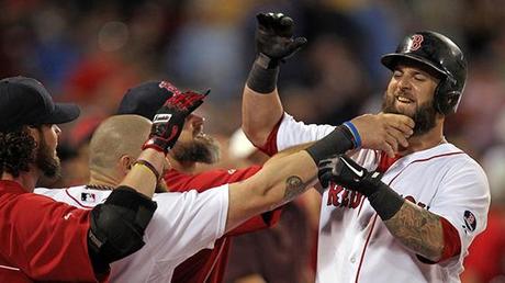 Bearded Boston Red Sox players rushing out of dugout to pull the beard of teammate who just hit a home run