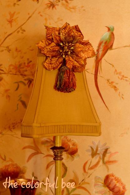 Putting Christmas Away fauc poinsettia and tassel on a lamp