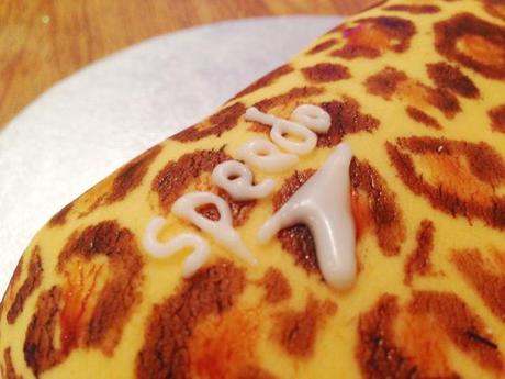 piped icing white speedo logo on personalised leopard print cake