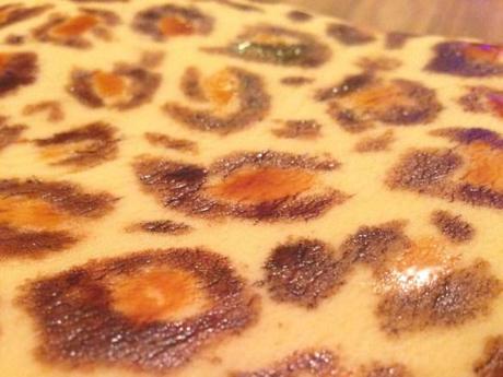 leopard print spots pattern hand painted onto cake using food colouring dark brown and tan on pastel base