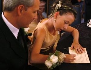 Ken Lane watches his daughter Hannah sign the purity covenant at the annual Father-Daughter Purity Ball in Colorado Springs
