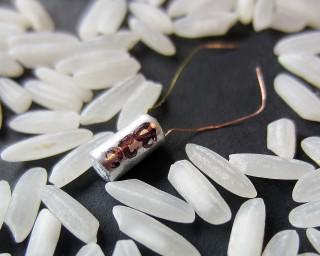 The microbattery created by Jie Xiao and Daniel Deng and colleagues, amid grains of rice