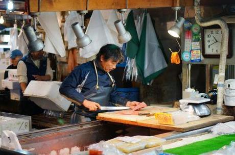 In the closing hours, this fishmonger remains hard at work slicing fish