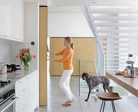 A Minimalist Duplex in Venice, California modern kitchen with sliding wood wall and concrete floors