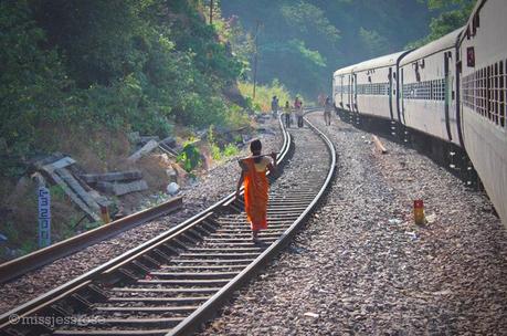 En route to Hampi, women construction workers walk along the train track