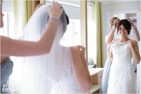 Yorkw edding photographer bride pus on veil and laughs