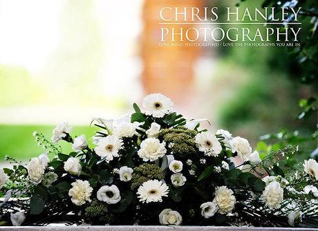 The top table wedding flowers: pure white roses, gerbera daisies, carnations and rich, dark green foliage.