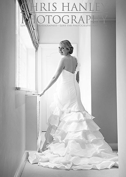 Amy's smile lights up this photograph while the soft natural sunlight brings the very best from the ruffles in her lovely wedding dress