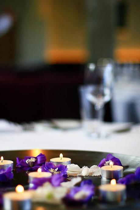 Simple table centrepieces with flowers and tealights - these are really pretty